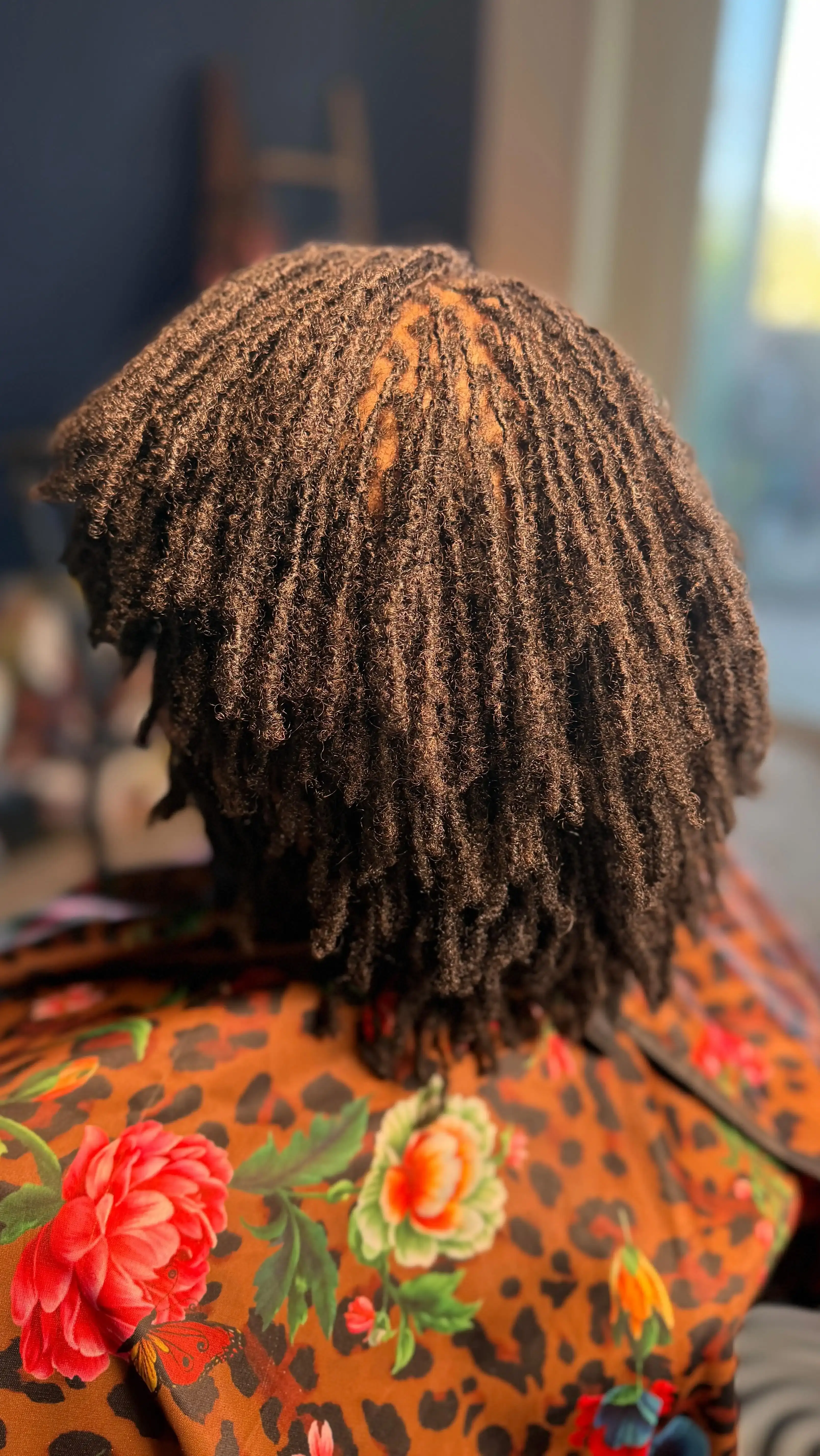 Client showcasing beautifully maintained locs with golden highlights