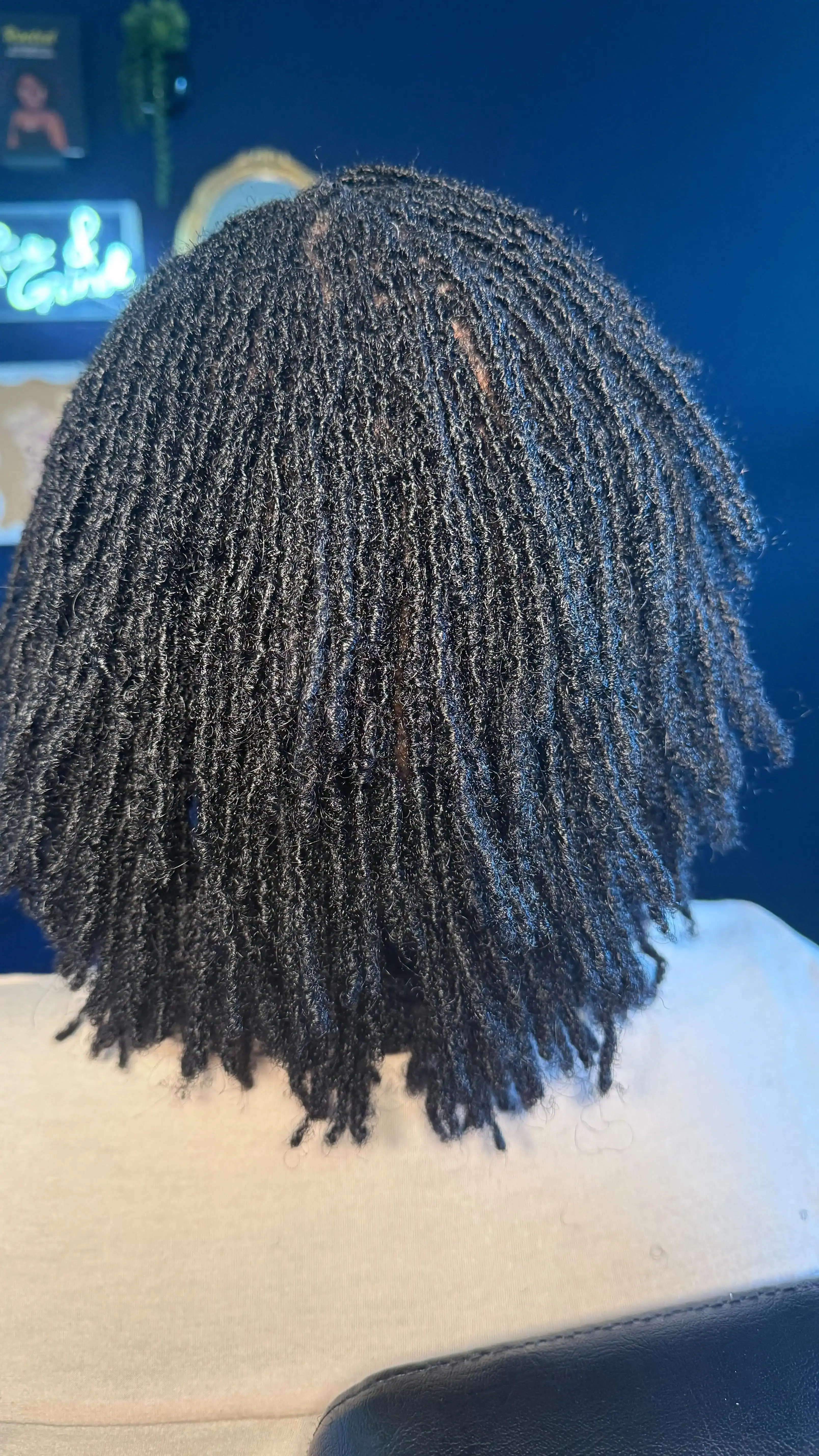 Client with rich dark locs demonstrating healthy loc growth and definition